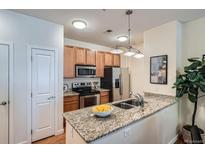 Bright kitchen featuring stainless steel appliances, granite countertops and ample cabinet space at 4100 Albion St # 611, Denver, CO 80216