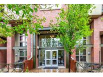 Inviting entrance of The Lofts at Central Park, showcasing brick facade and modern glass doors at 7700 E 29Th Ave # 405, Denver, CO 80238