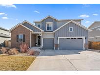 Beautiful two-story home with a mix of brick and siding, a well-manicured lawn, and a two-car garage at 11926 Olive St, Thornton, CO 80233