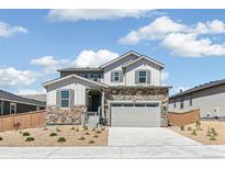 Charming two-story home featuring stone accents, gray siding and a two-car garage at 4451 Soapberry Pl, Castle Rock, CO 80108