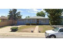 Ranch style home with attached garage and well-maintained lawn at 1180 Walnut St, Brighton, CO 80601