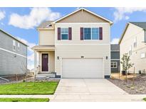 Charming two-story home featuring a two-car garage and a well-manicured lawn on a sunny day at 1638 Plata St, Lochbuie, CO 80603