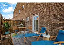 Relaxing outdoor patio featuring comfortable lounge chairs and table set against a brick wall backdrop at 70 N Grant St # 10, Denver, CO 80203
