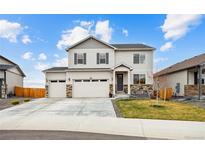 Charming two-story home featuring a three-car garage, stone accents, and a well-maintained front yard at 14696 Bonsmara Dr, Mead, CO 80542