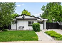 Charming white and black home featuring a swing, black framed windows, and a well-manicured lawn at 1264 Uinta St, Denver, CO 80220
