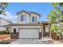 Charming two-story home featuring a two-car garage, brick accents, and a welcoming front porch at 20558 E Grand Ln, Aurora, CO 80015