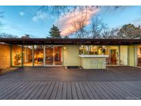Home's exterior featuring a spacious deck, outdoor bar, and expansive windows, perfect for indoor-outdoor living at 5450 Mohawk Rd, Littleton, CO 80123
