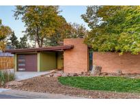 Charming single-story home with a well-manicured front yard, appealing brickwork, and an attached garage at 5450 Mohawk Rd, Littleton, CO 80123