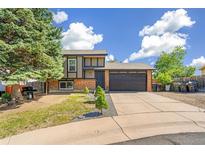 Charming two-story home features a brick facade, well-maintained lawn, and an attached two-car garage at 9605 Orangewood Dr, Thornton, CO 80260