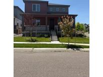 Charming two-story home featuring a covered front porch and well-manicured lawn at 17822 E 107Th Pl, Commerce City, CO 80022
