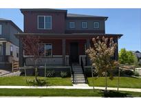 Charming two-story home featuring a welcoming front porch and landscaped front yard at 17822 E 107Th Pl, Commerce City, CO 80022