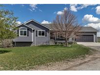 Charming home with manicured lawn, covered porch and two-car garage at 2996 Savage Rd, Elizabeth, CO 80107