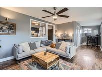 Comfortable living room boasts a modern ceiling fan and an open design to the office area at 1655 S Lowell Blvd, Denver, CO 80219