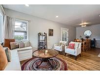 Inviting living room with hardwood floors, colorful rug, and cozy window seat with natural light at 1655 S Lowell Blvd, Denver, CO 80219