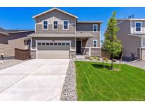 Charming two-story home with a well-manicured lawn and a two car garage on a sunny day at 18961 E 96Th Pl, Commerce City, CO 80022