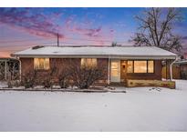 Brick ranch house with snowy front yard at 4730 Carr St, Wheat Ridge, CO 80033