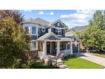 Charming two-story home with a well-maintained lawn, inviting porch, and beautiful, mature landscaping at 16376 Stonefeld Pl, Parker, CO 80134