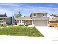 Charming two-story home with a well-manicured lawn and attached two-car garage at 12089 W Burgundy Ave, Littleton, CO 80127