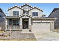 Charming two-story home featuring stone accents, gray siding, and a covered front porch at 24715 E Evans Dr, Aurora, CO 80018