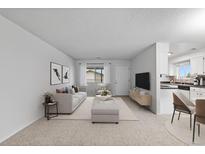 Bright living room with open concept floor plan, featuring a sofa and adjacent dining area at 9868 Appletree Pl, Thornton, CO 80260