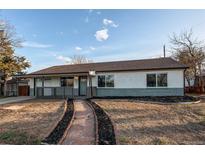 Charming single-story home with a landscaped front yard and welcoming stone pathway at 795 Troy Ct, Aurora, CO 80011