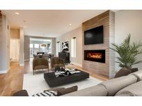 Bright living room featuring a modern fireplace, hardwood floors, and neutral decor at 3122 Perry St, Denver, CO 80212