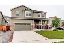 Two-story home with a two car garage, landscaped yard, and a covered porch at 9250 Rifle St, Commerce City, CO 80022