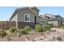 Charming home with grey siding, brick accents, and landscaping at 6924 E 118Th Pl, Thornton, CO 80233