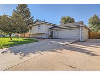 Split level home with an attached garage, spacious driveway, and a well manicured lawn at 6069 S Marshall Dr, Littleton, CO 80123