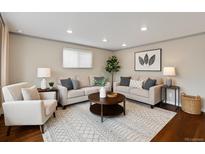 Bright living room features hardwood floors, neutral paint, two sofas, arm chair, coffee table, and recessed lighting at 1996 S Dexter St, Denver, CO 80222