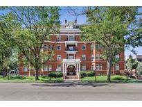 Elegant brick building with classic architectural details and mature trees at 836 E 17Th Ave # 1A, Denver, CO 80218