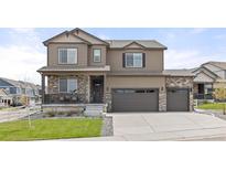 Charming two-story home featuring stone accents, a covered porch, and a three-car garage at 2040 Rosette Pl, Castle Rock, CO 80104