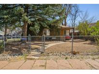 Charming ivy-covered bungalow home with a fenced yard and mature trees at 2000 S Columbine St, Denver, CO 80210
