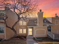 Charming two-story townhouse with a stucco exterior, covered entry, and manicured landscaping at sunset at 2862 S Vaughn Way, Aurora, CO 80014