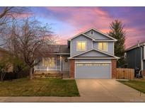 Charming two-story home with a blue exterior, front porch, well-manicured lawn, and an attached two-car garage at 11402 Benton Ct, Westminster, CO 80020