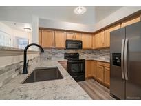 Modern kitchen featuring stainless steel appliances and a beautiful backsplash at 5465 Zephyr St # 201, Arvada, CO 80002