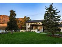 Stunning modern home boasting lush lawn, mature trees, and mountain views at 17326 W 57Th Ave, Golden, CO 80403
