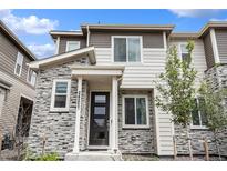Charming townhome with stone facade, modern black door, and well-maintained landscaping at 24257 E 41St Ave, Aurora, CO 80019