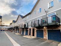 Row of gray townhomes with brick garages and black iron balconies create curb appeal at 2951 W Riverwalk Cir # N, Littleton, CO 80123