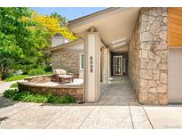 Inviting front entrance with stone accents, seating area, and a well-maintained walkway at 6008 S Van Gordon St, Littleton, CO 80127