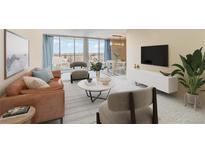 Inviting living room with comfortable seating, a modern TV, and a large window with beautiful outdoor views at 955 Eudora St # 708E, Denver, CO 80220