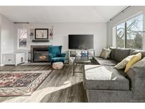 Comfortable living room featuring a fireplace, large sectional sofa, and lots of natural light from the large window at 540 S Forest St # 6-203, Denver, CO 80246