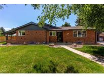Charming brick home featuring a lush green lawn and a cozy, inviting entrance at 6572 E Dakota Ave, Denver, CO 80224