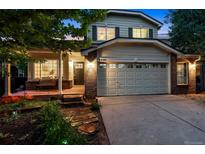 Charming two-story home featuring a large front-facing two car garage and brick accents at 1441 Cherry Pl, Erie, CO 80516