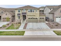 Two-story home with a three-car garage, stone accents, and concrete driveway in a residential neighborhood at 22472 E Narrowleaf Cir, Aurora, CO 80016