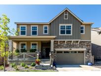 Charming two-story home with a stone-accented facade, covered porch, and well-maintained landscaping at 24326 E Ohio Dr, Aurora, CO 80018