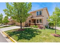 Charming townhome features a landscaped front yard with mature trees and desert landscaping at 9117 Nambe Trl, Lone Tree, CO 80124