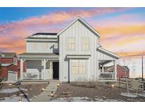 Two-story farmhouse with solar panels, front porch, and landscaped yard at 8373 Rush Creek Ave, Littleton, CO 80125