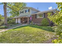 Charming two-story home featuring a well-maintained lawn and inviting front porch with seating at 6857 S Franklin Cir, Centennial, CO 80122