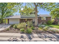 Charming home with brick and siding, a well-manicured lawn, and an attached two car garage at 6857 S Franklin Cir, Centennial, CO 80122